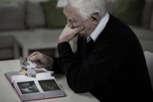 elderly man holding photographs