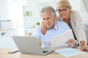 elderly couple in front of laptop