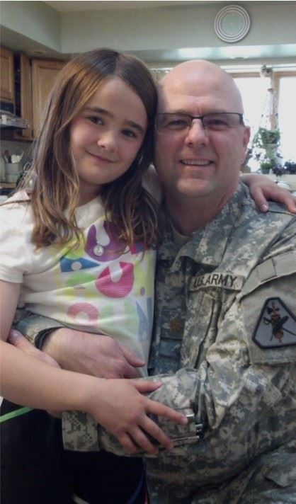 Dan in army uniform hugging daughter